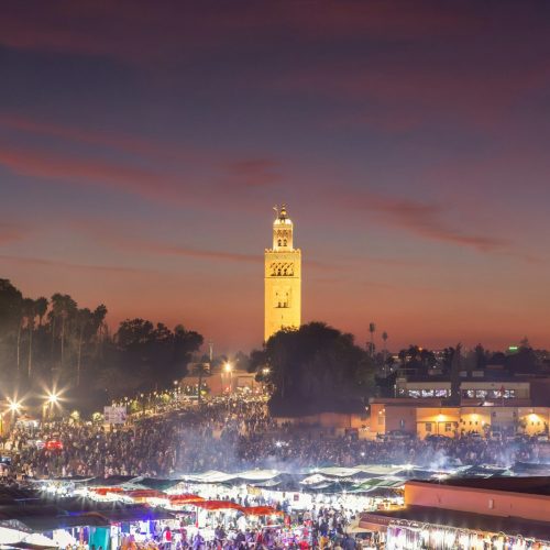 A large crowd of people standing around a city at night